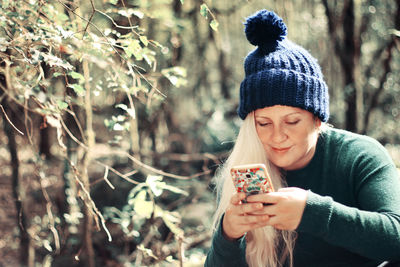 Mid adult man using mobile phone in forest