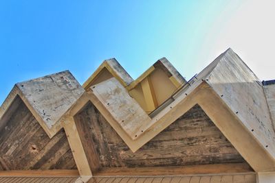 Low angle view of wooden house against clear blue sky