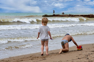 Rear view of woman standing at beach