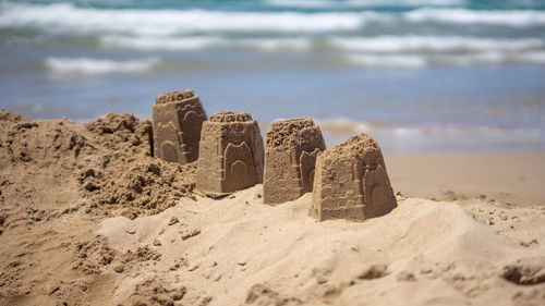 Close-up of lounge chairs on sand at beach