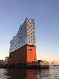Building by sea against clear sky