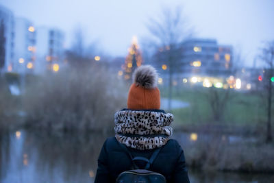 Rear view of woman on snow covered city in winter