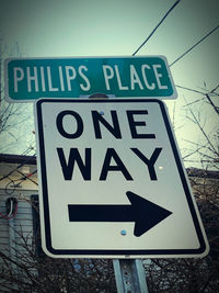 Close-up of road sign against sky