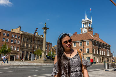 Portrait of smiling young woman standing in city