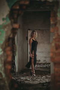 Portrait of woman standing against wall
