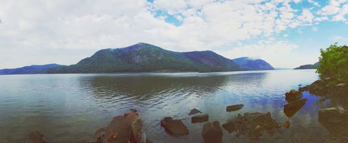 Low section of mountain by lake against sky