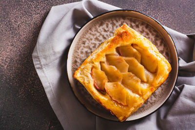 Close up of upside down puff pastry apple tart on a breakfast plate top view