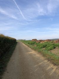 Road leading towards landscape against sky