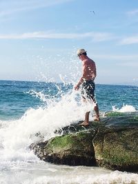 Full length of man jumping on beach against sky