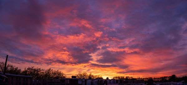 Panoramic view of buildings against dramatic sky during sunset