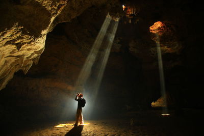 Man standing on rock in cave