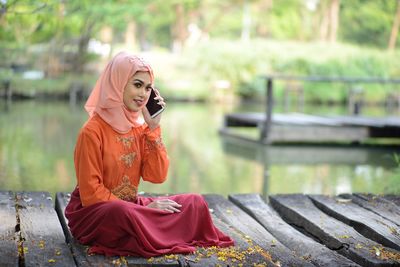 Young woman looking down while sitting outdoors