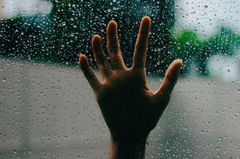 Human hand on transparent glass