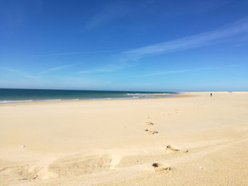 Scenic view of beach against blue sky