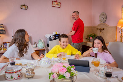 Full length of father and daughter while sitting on table