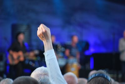 Man with hand raised in crowd during concert