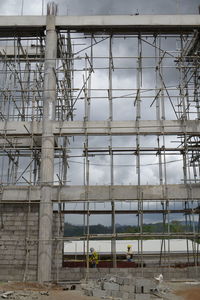 People working at construction site against sky