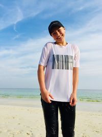 Low angle view of woman standing at beach against sky