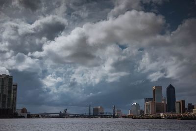 Modern buildings by sea against sky in city