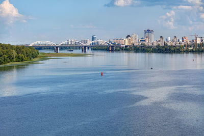 A view of the dnipro, the railway bridge and new residential areas of kyiv on the horizon.