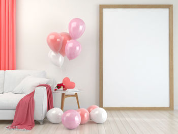 Multi colored balloons on table against wall at home