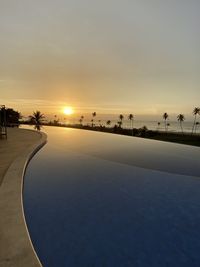 Scenic view of swimming pool against sky during sunset