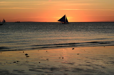 Silhouette sailboat on sea against sky during sunset