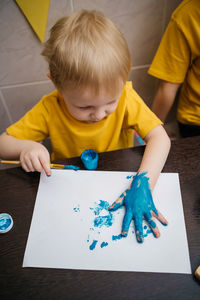 Hands of painting little boy and the table for creativity.hand kids painting. high quality photo