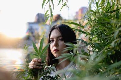 Portrait of young woman amidst plants