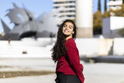 Portrait of smiling teenage girl standing in city