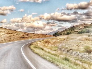 Road passing through landscape against sky