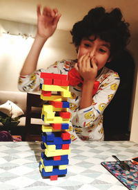 Portrait of boy sitting on table at home
