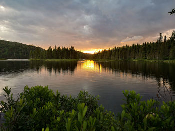 Scenic view of lake against sky at sunset