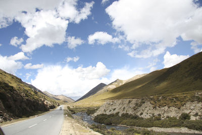 Road leading towards mountains against sky