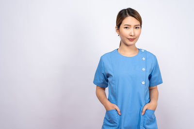 Portrait of smiling young woman against white background