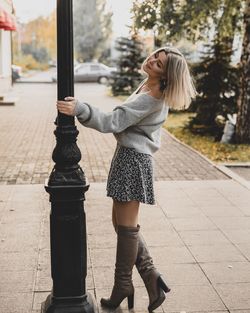 Full length of woman standing on footpath