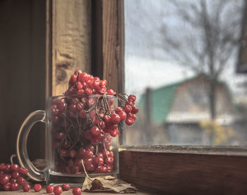 Close-up of red berries on glass window
