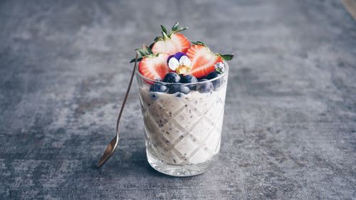 Close-up of smoothie garnished with fruits on table