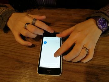 Close-up of woman using mobile phone on table