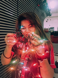 Full length portrait of woman holding illuminated lights