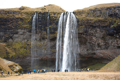 Group of people on rock against the sky