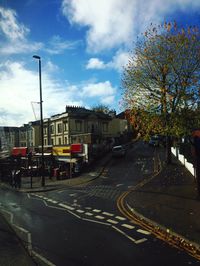 Cars on city street against sky