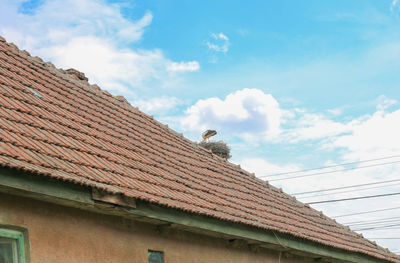 Low angle view of house roof against sky