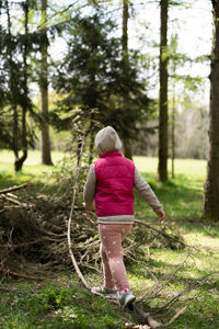 Rear view of woman standing in forest