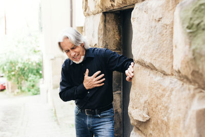 Portrait of man standing against wall