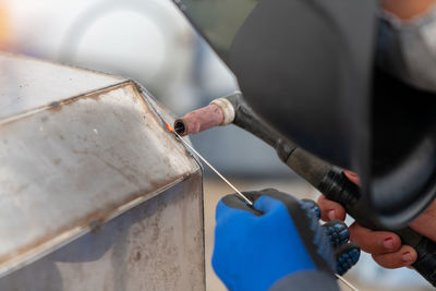 Welder ware blue gloves welding stainless steel tank at industry