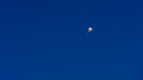 Low angle view of moon against clear blue sky