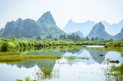 Scenic view of lake and mountains against sky