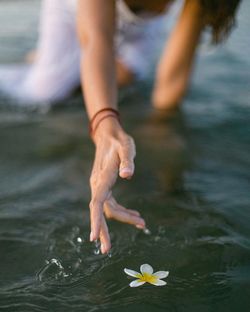 Midsection of woman floating on water in lake