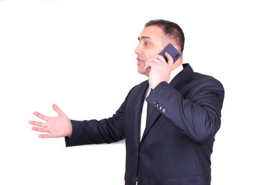 Young man using mobile phone against white background